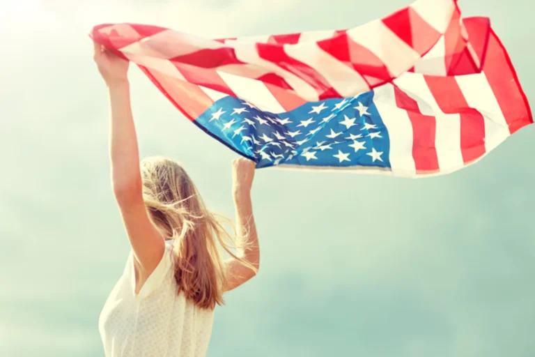 Teen girl holding with American flag in the breeze