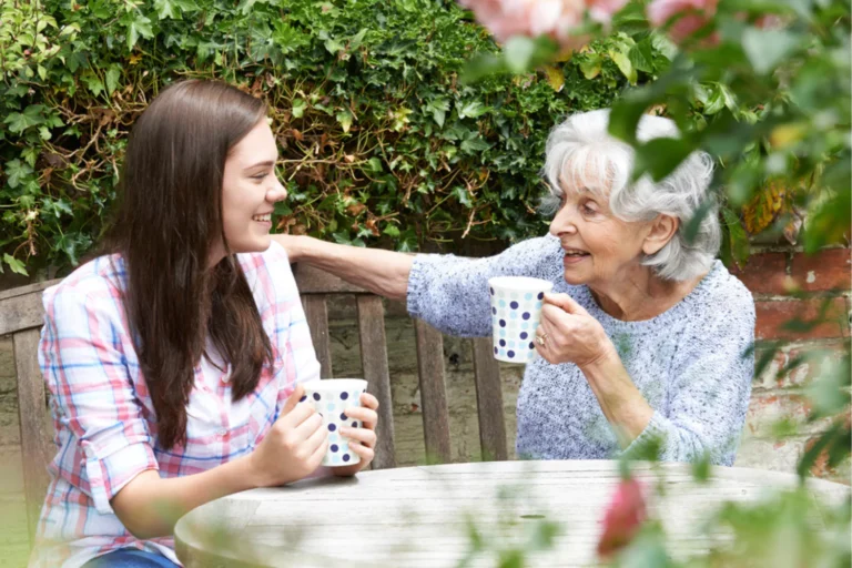 Grandmother and teenaged granddaughter having tea