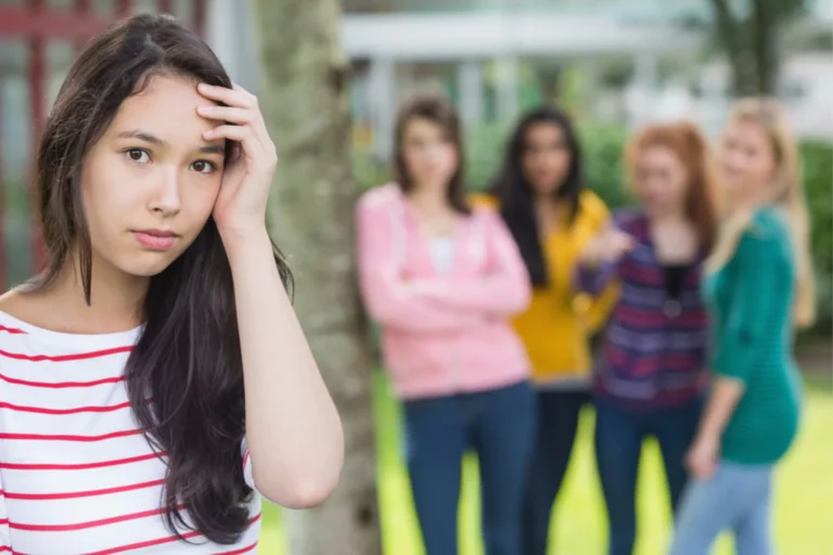 teen girl dealing with the rejection of her four peer in the background