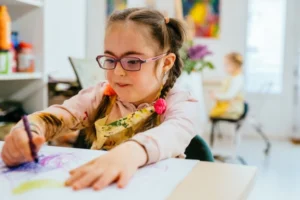 cute little girl with down syndrome coloring