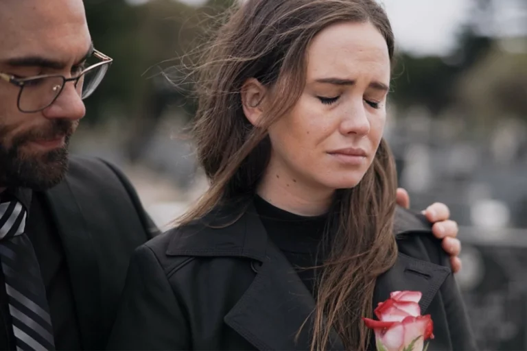 When a baby dies parents are left to grieve with empty arms. Mother and father holding a rose attending the funeral of their child